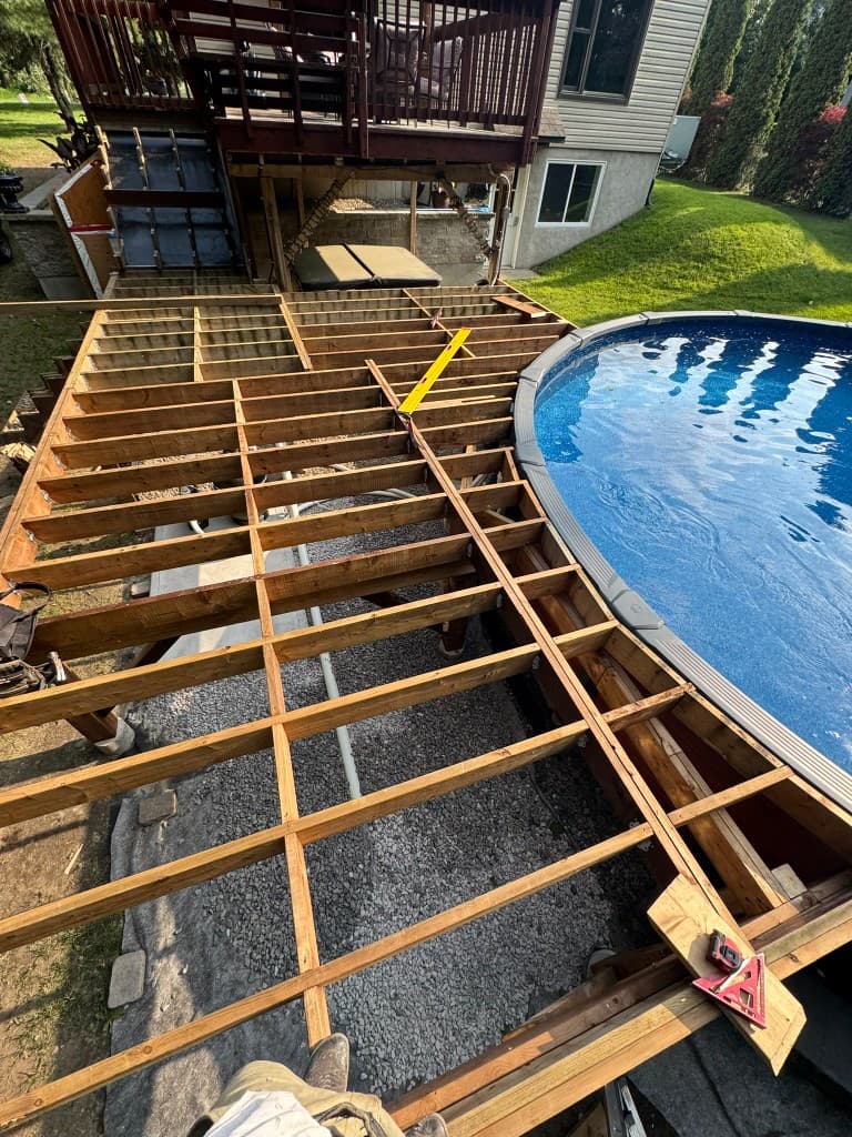 Charpente de terrasse en construction autour d'une piscine courbe par Calco Construction